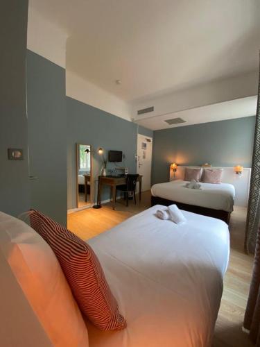 a hotel room with two beds and a desk at Hotel De L'Océan in Biarritz