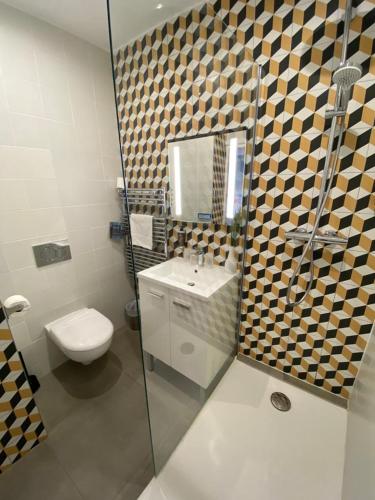 a bathroom with a toilet and a sink and a shower at Hotel De L'Océan in Biarritz