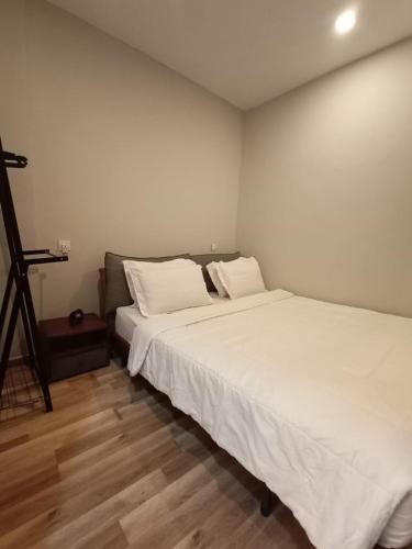 a bedroom with two beds with white sheets and a tripod at Casanova Penuin Batam in Nagoya