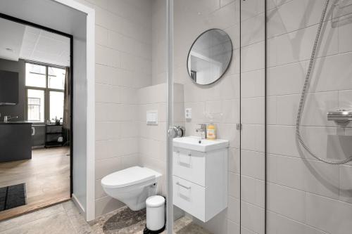 a bathroom with a toilet and a sink and a mirror at Forenom Serviced Apartments Drammen in Drammen