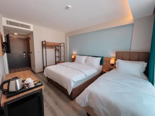 a hotel room with two beds and a table at Yalçındağ Otel Burdur in Burdur