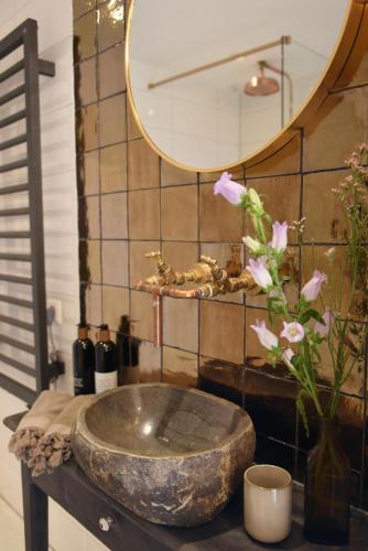 a bathroom with a stone sink and a mirror at Smuk Huske in Echtenerbrug