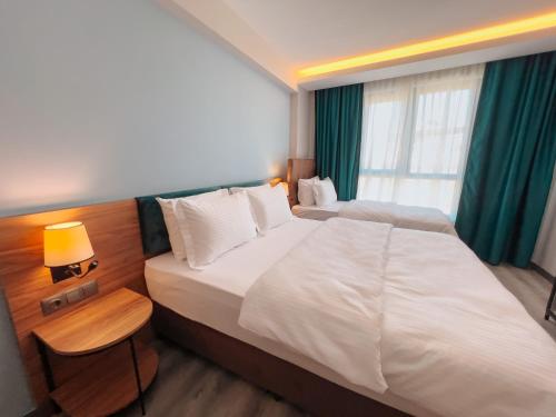 a hotel room with two beds and a window at Yalçındağ Otel Burdur in Burdur