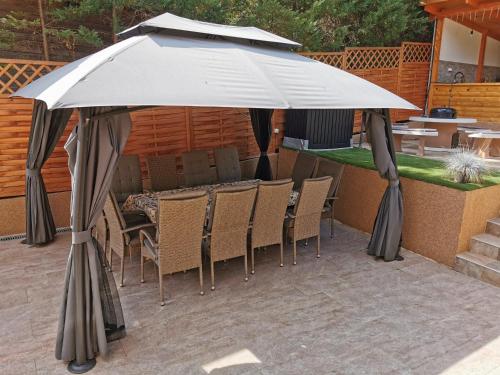 a large white umbrella sitting on a patio at Bükki Villa in Bükkszék