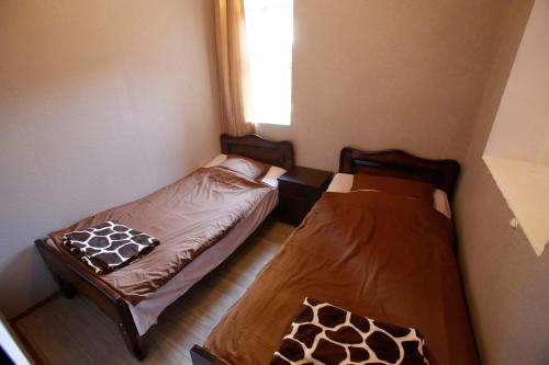 2 camas individuais num pequeno quarto com uma janela. em Mshvidoba em Ushguli