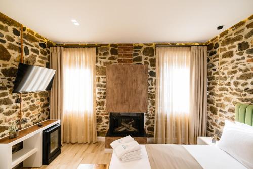 a bedroom with a fireplace in a stone wall at Vecchia Boutique Hotel in Korçë