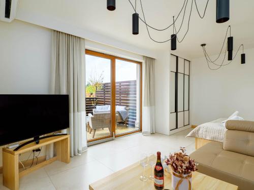 a living room with a television and a couch at Apartamenty Hrube Niżne 23D in Zakopane