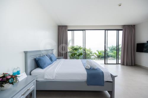 1 dormitorio con 1 cama grande con almohadas azules en Cozrum Luxury - Aria Resort Vũng Tàu en Xã Thắng Nhứt