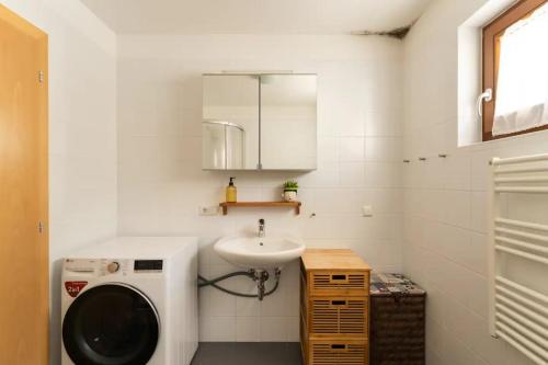 a bathroom with a washing machine and a sink at Holiday Home Julia in Valdaora