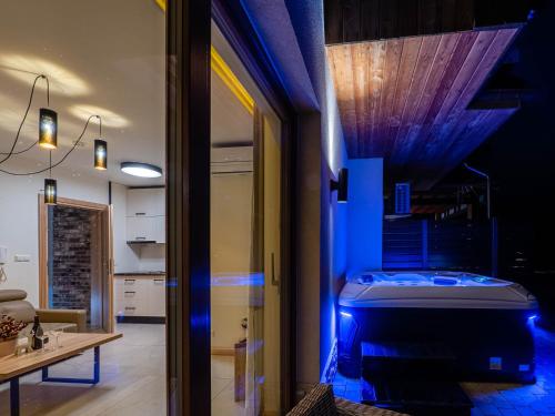 Cette chambre dispose d'une baignoire avec des lumières bleues. dans l'établissement Apartamenty Hrube Niżne 23D, à Zakopane