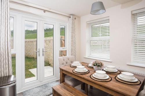 a dining room with a table and a window at Peak District New Modern Cottage with Mountain Views in Buxton