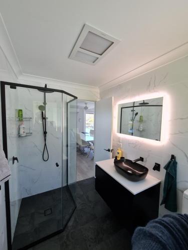 a bathroom with a sink and a glass shower at Magic in Medlow in Medlow Bath