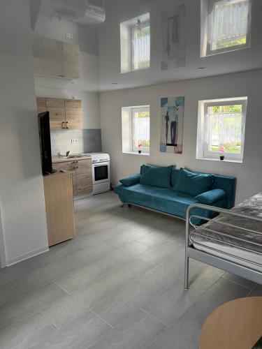 a living room with a blue couch and a kitchen at Tatiana Feuker in Borgentreich