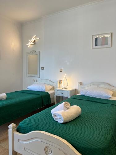 a bedroom with two beds with green sheets at Katerina Apartments & Studios in Naousa
