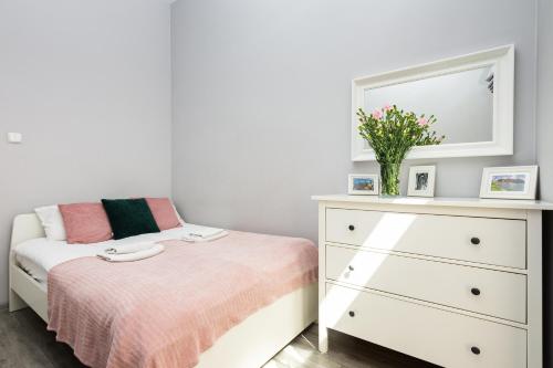 a bedroom with a bed and a dresser with a mirror at Luxury Apartments Old Town Topolowa in Kraków