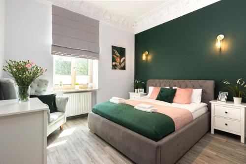 sypialnia z łóżkiem i zieloną ścianą w obiekcie Luxury Apartments Old Town Topolowa w Krakowie
