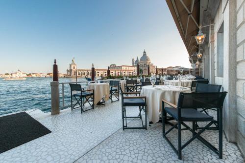 a restaurant with tables and chairs next to the water at Monaco & Grand Canal in Venice