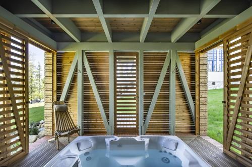 uma banheira num quarto com persianas de madeira em Vila Lavina em Nový Smokovec