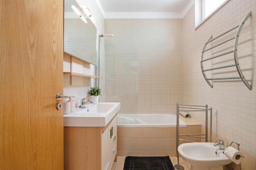 uma casa de banho com um lavatório, uma banheira e um WC. em Santa Luzia Apartment Sl005 em Tavira