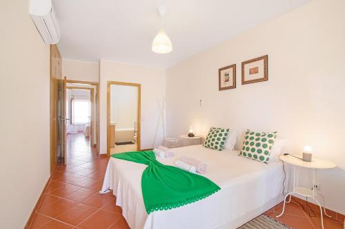 um quarto com uma cama com um cobertor verde em Santa Luzia Apartment Sl005 em Tavira