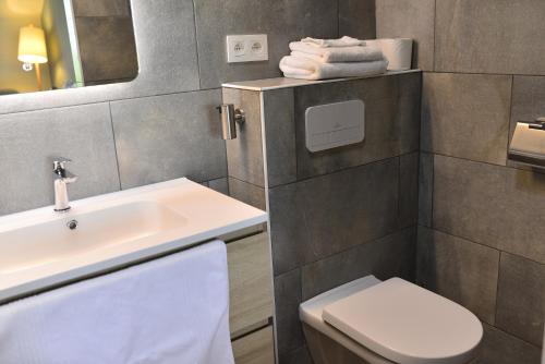 ein Badezimmer mit einem weißen Waschbecken und einem WC in der Unterkunft Entre Champs in Ohain