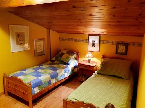 - une chambre avec deux lits et un plafond en bois dans l'établissement Accogliente attico vista Dolomiti, à Vodo Cadore