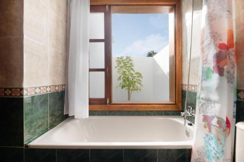 a bathroom with a bath tub and a window at Casa Aloe in Haría