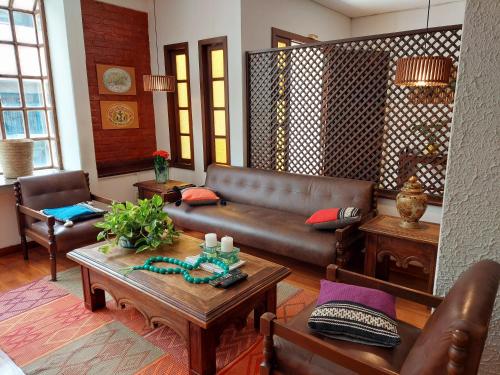 a living room with a leather couch and a table at Hotel Mount Everest in Nova Friburgo