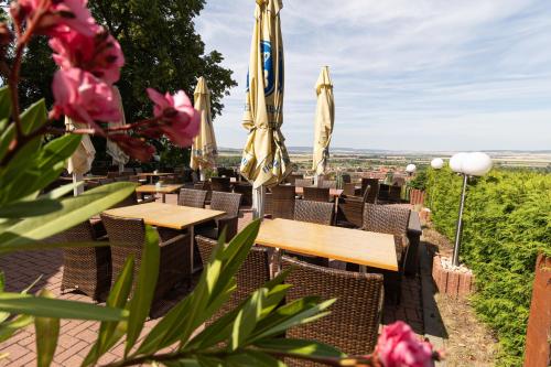 a restaurant with tables and umbrellas and flowers at Hotel-Restaurant Weinberg in Artern
