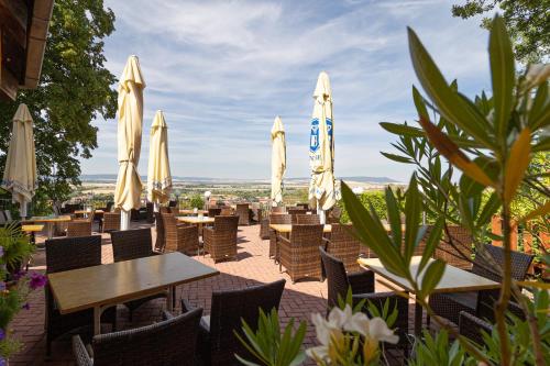 a restaurant with tables and chairs and umbrellas at Hotel-Restaurant Weinberg in Artern