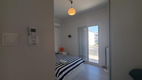 een witte kamer met een bed en een raam bij Armenian Huts - Beach Apartments in Vari