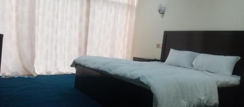 a bedroom with a large bed with a large window at Venus Mountain Resort, Hunza in Hunza