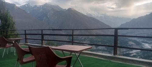 a table and chairs on a balcony with a view of mountains at Venus Mountain Resort, Hunza in Hunza