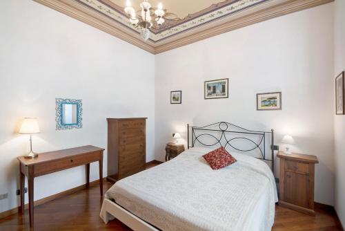 a bedroom with a bed and two tables and a chandelier at A due passi dal mare in Chiavari