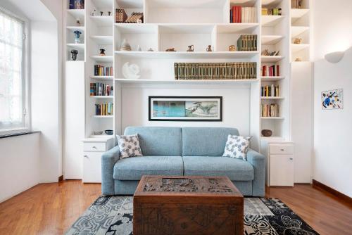 a living room with a blue couch and bookshelves at A due passi dal mare in Chiavari