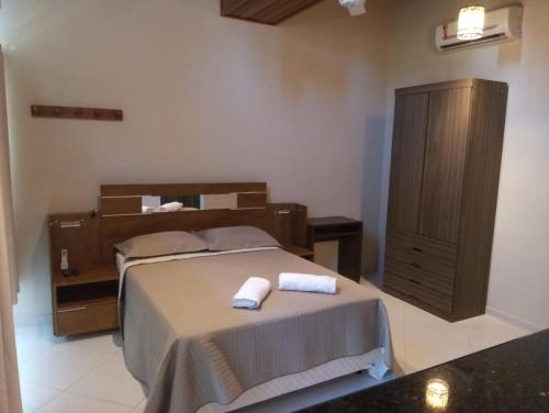 - une chambre avec un lit et 2 serviettes dans l'établissement POUSADA CAMINHO DAS ÁGUAS, à Arraial do Cabo