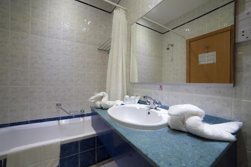 La salle de bains est pourvue d'un lavabo et d'une baignoire. dans l'établissement Bella Vista Hotel, à San Pawl il-Baħar