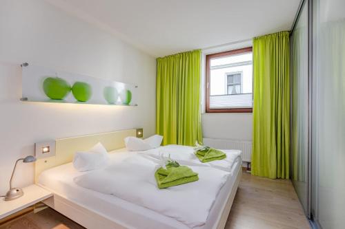 - une chambre avec un lit blanc et des rideaux verts dans l'établissement Villa Medici 10 a, à Ahlbeck
