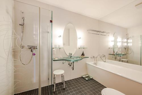 une salle de bain avec un lavabo, une baignoire et une douche dans l'établissement Villa Medici 10 a, à Ahlbeck