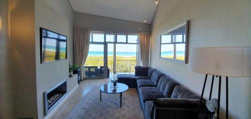 a living room with a couch and a fireplace at Beachfront 3-bedroom with Robben Island views in Cape Town