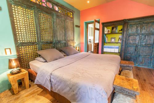Pancé的住宿－Presbytère de Pancé，一间卧室配有一张带橙色墙壁的大床