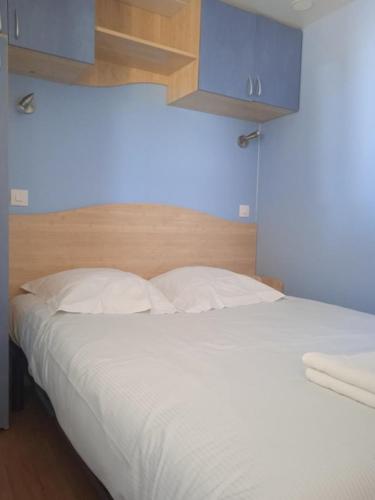 a bedroom with a large white bed with blue cabinets at Olydea le Lambon - Prailles-la-Couarde in Prailles