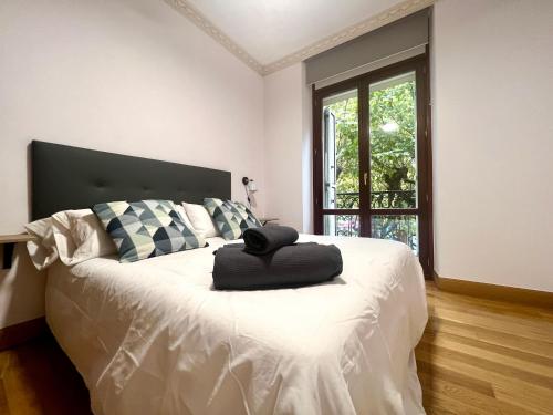 a bedroom with a bed with a black hat on it at Avenida 12 apartment in San Sebastián