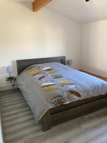 Una cama en un dormitorio con una colcha con pescado. en Le Matadri, en Grane