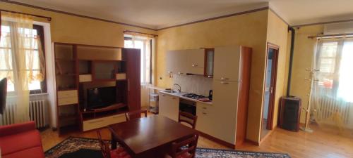 a living room with a kitchen with a table at TETTI DI LANGA - Abita nel cuore di La Morra in La Morra