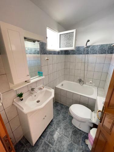 a bathroom with a toilet and a sink and a tub at Artemis Hotel Apartments in Keramotí