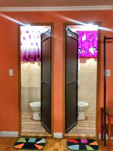 a bathroom with two stalls with toilets in it at Cardo Homestay Siargao in General Luna