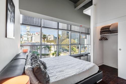 a bedroom with a bed and a large window at Heaven on Hollywood Furnished Apartments in Los Angeles