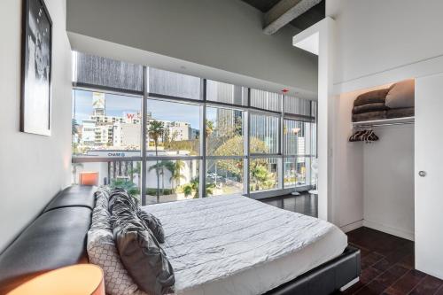 1 dormitorio con cama y ventana grande en Heaven on Hollywood Furnished Apartments, en Los Ángeles