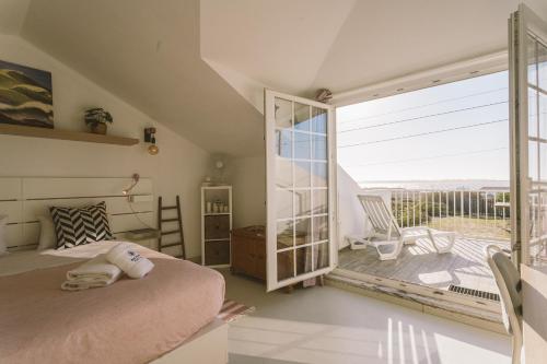 1 dormitorio con cama y ventana grande en Best Houses 26: Baleal Beach Front Retreat, en Ferrel